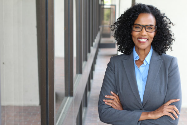 A woman in glasses and a suit standing outside